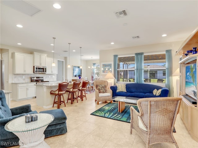 living room with light tile patterned flooring and a notable chandelier