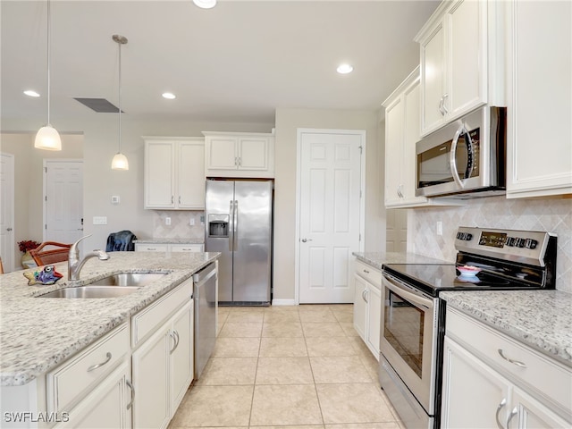 kitchen featuring sink, an island with sink, decorative light fixtures, light tile patterned flooring, and appliances with stainless steel finishes