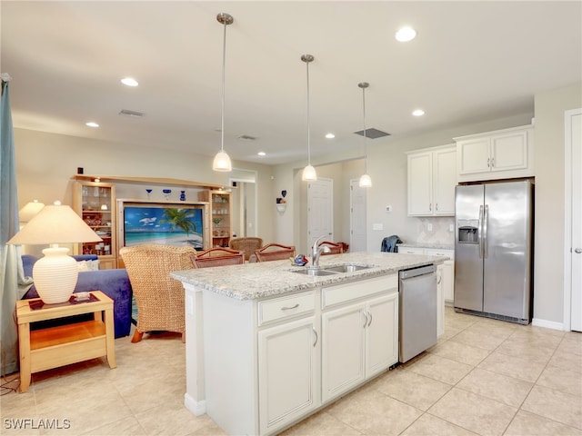 kitchen with sink, an island with sink, decorative light fixtures, white cabinetry, and stainless steel appliances