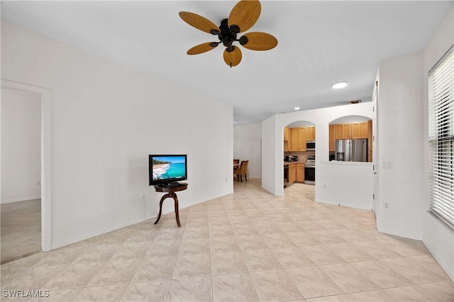 unfurnished living room featuring ceiling fan and light tile patterned floors