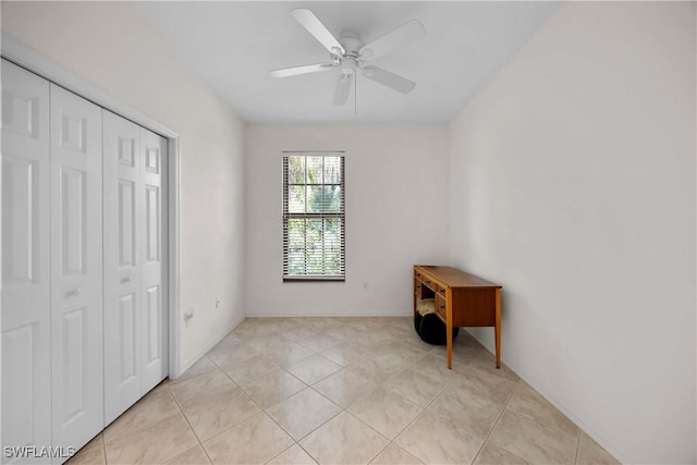 bedroom featuring light tile patterned floors, a closet, and ceiling fan