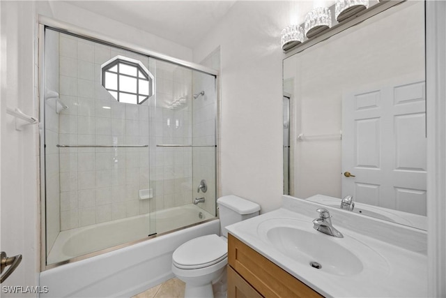 full bathroom featuring tile patterned flooring, vanity, toilet, and bath / shower combo with glass door