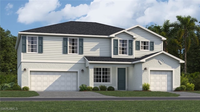 view of property with a garage and a front lawn