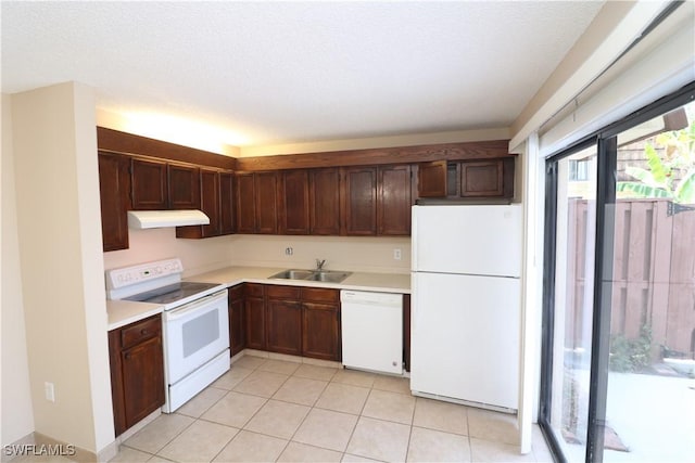 kitchen featuring sink, white appliances, a textured ceiling, and light tile patterned floors