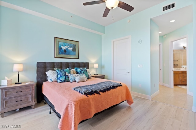 bedroom featuring a closet, light hardwood / wood-style floors, ensuite bath, and ceiling fan