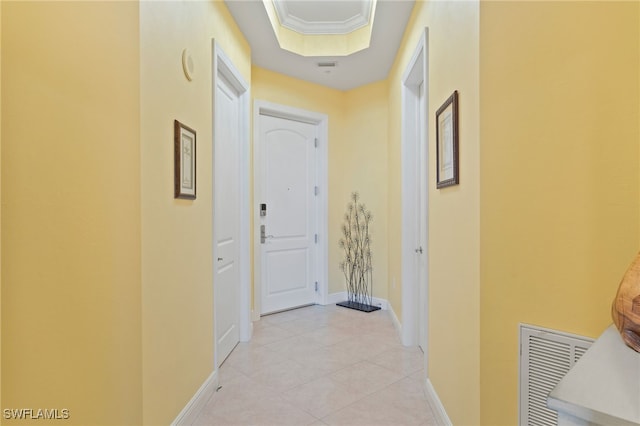 hall featuring a tray ceiling and ornamental molding