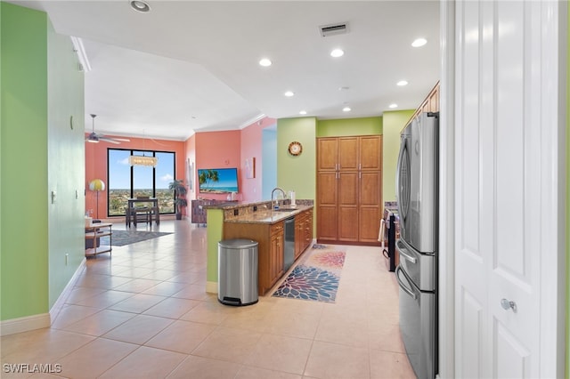 kitchen with ceiling fan, light tile patterned floors, appliances with stainless steel finishes, stone countertops, and kitchen peninsula