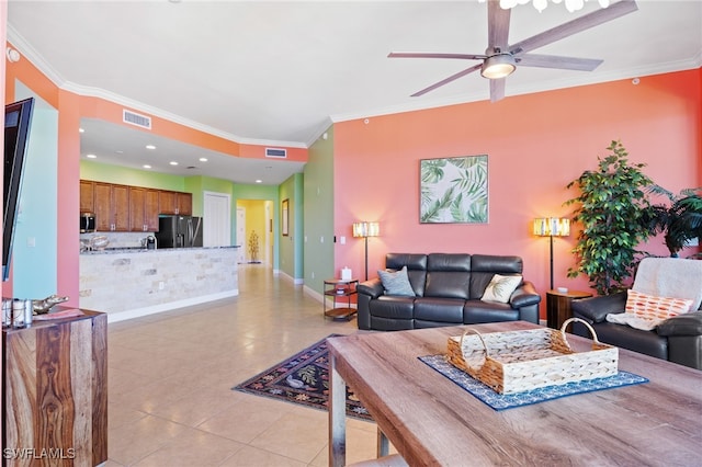 tiled living room with ceiling fan and ornamental molding