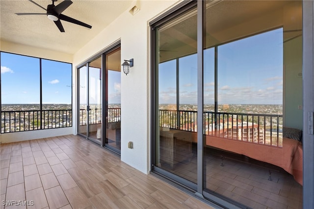 unfurnished sunroom with ceiling fan