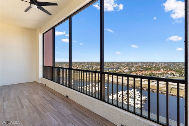 unfurnished sunroom with a water view and ceiling fan