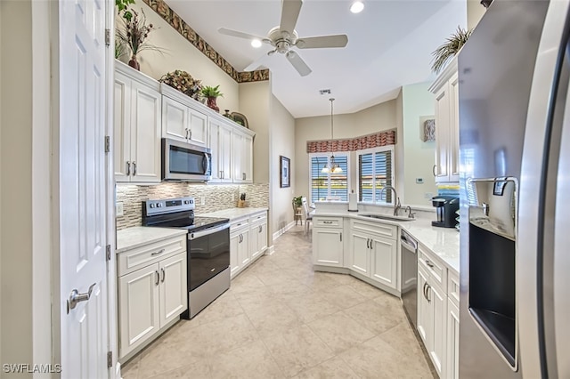 kitchen with white cabinetry, sink, hanging light fixtures, ceiling fan with notable chandelier, and appliances with stainless steel finishes