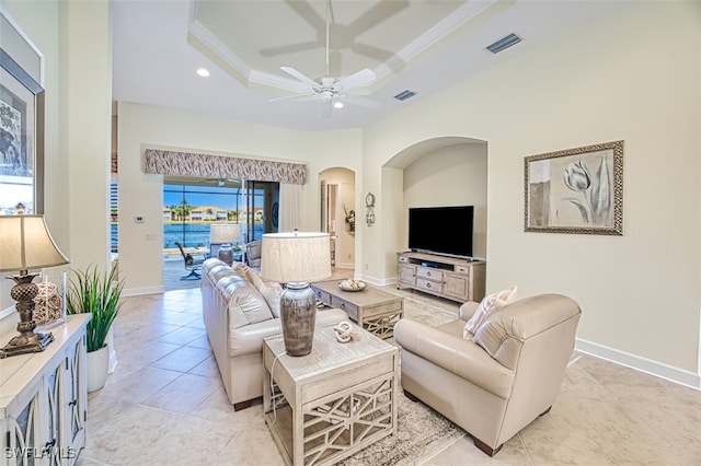 tiled living room with ceiling fan, crown molding, and a tray ceiling