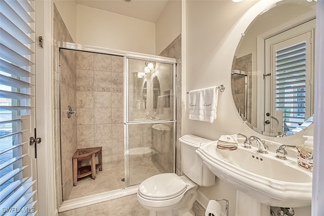 bathroom featuring sink, tile patterned flooring, a shower with shower door, and toilet