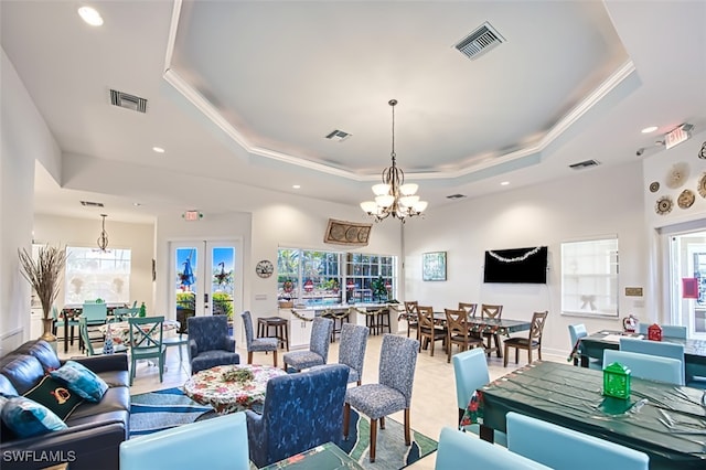 living room with french doors, an inviting chandelier, a raised ceiling, and crown molding