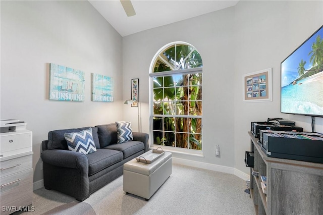 living room with ceiling fan, high vaulted ceiling, and light colored carpet