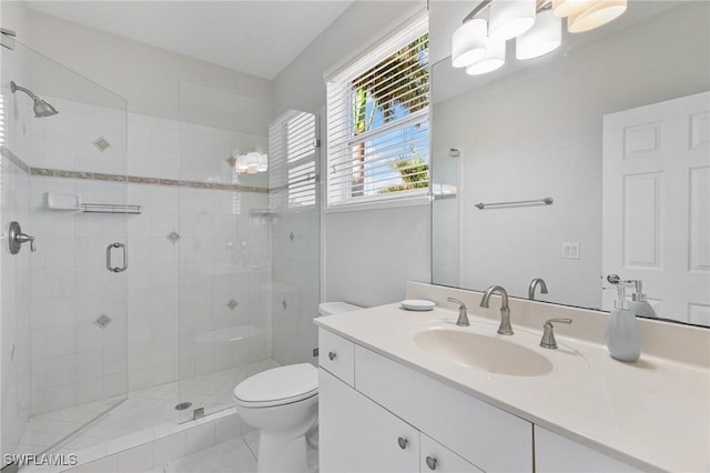 bathroom featuring tile patterned floors, vanity, toilet, and a shower with door