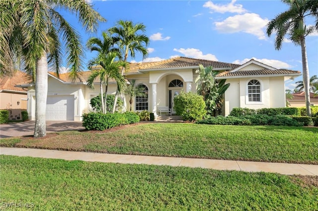 mediterranean / spanish-style house with a garage and a front yard