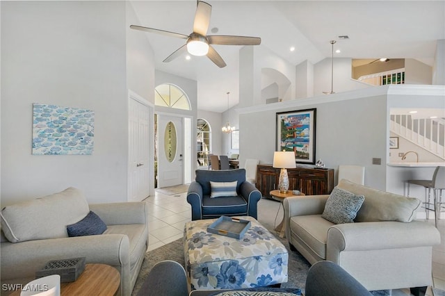 living room featuring ceiling fan with notable chandelier, light tile patterned floors, and high vaulted ceiling