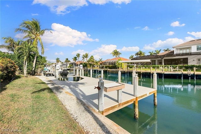 view of dock featuring a lawn and a water view