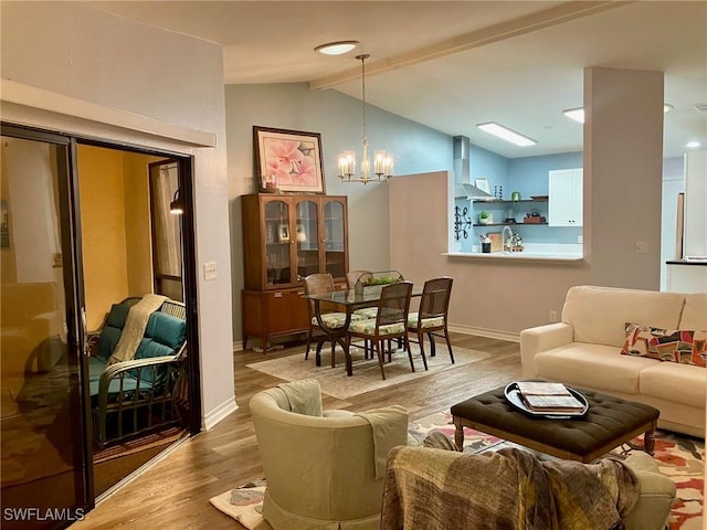 living room with lofted ceiling with beams, a notable chandelier, and hardwood / wood-style floors