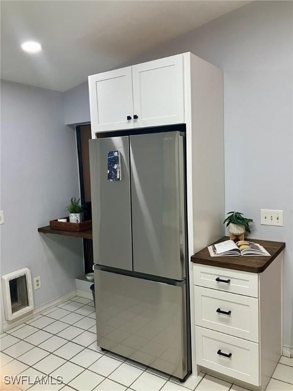 kitchen featuring white cabinets and stainless steel refrigerator