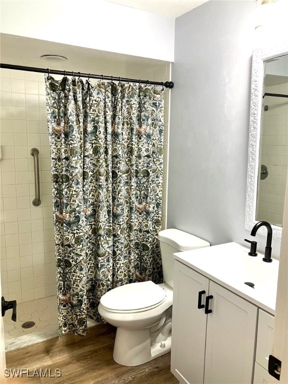 bathroom with toilet, vanity, a shower with curtain, and hardwood / wood-style floors