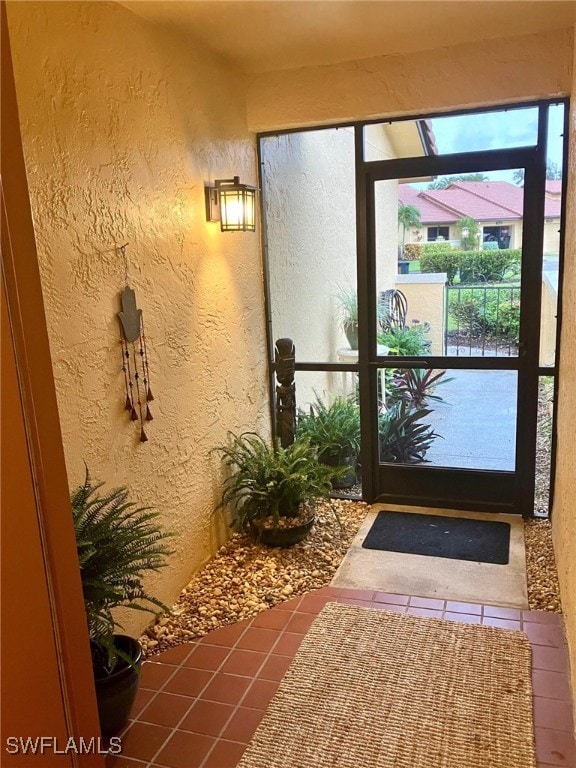 doorway to outside featuring a healthy amount of sunlight and tile patterned floors