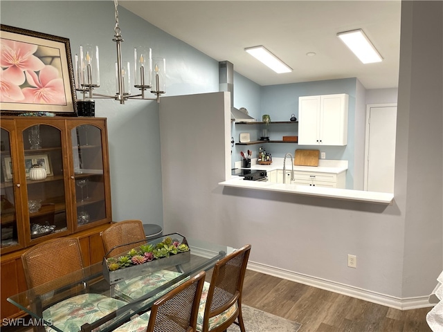 dining area featuring an inviting chandelier, dark hardwood / wood-style floors, and sink