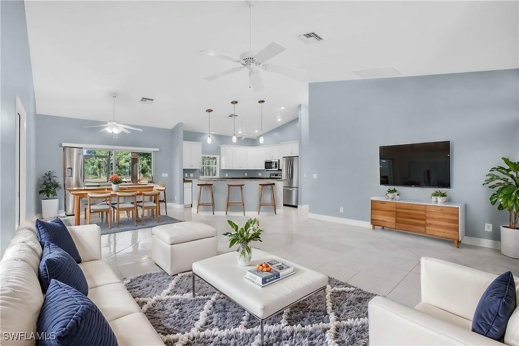 living room with high vaulted ceiling and light tile patterned flooring