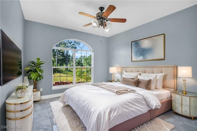 tiled bedroom featuring ceiling fan