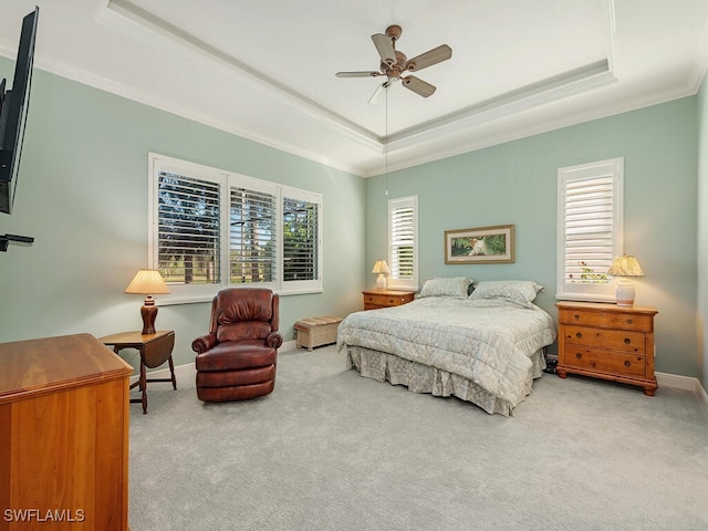 carpeted bedroom featuring a tray ceiling, ceiling fan, and crown molding