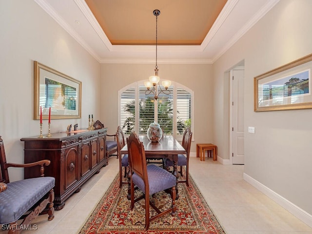 dining space with a tray ceiling, crown molding, and an inviting chandelier