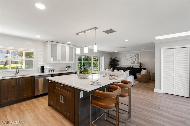 kitchen featuring white cabinets, stainless steel dishwasher, plenty of natural light, and sink