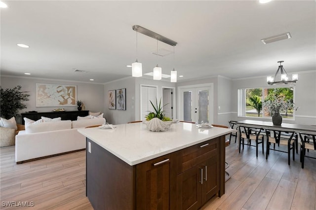 kitchen featuring ornamental molding, hanging light fixtures, french doors, and light hardwood / wood-style floors