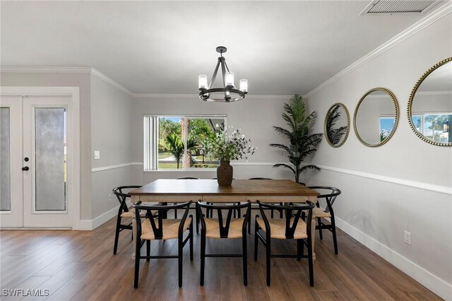 dining room featuring dark hardwood / wood-style floors, ornamental molding, french doors, and a chandelier