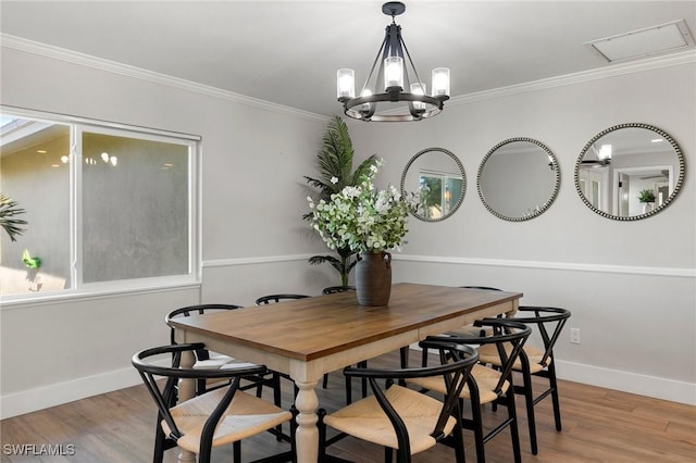 dining space featuring wood-type flooring, an inviting chandelier, and ornamental molding