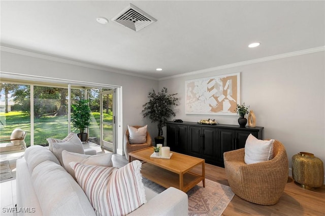 living room featuring crown molding and light hardwood / wood-style flooring