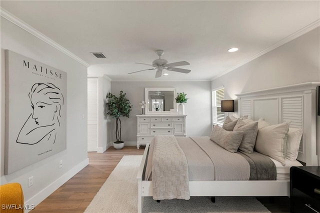 bedroom with ceiling fan, crown molding, and light hardwood / wood-style floors