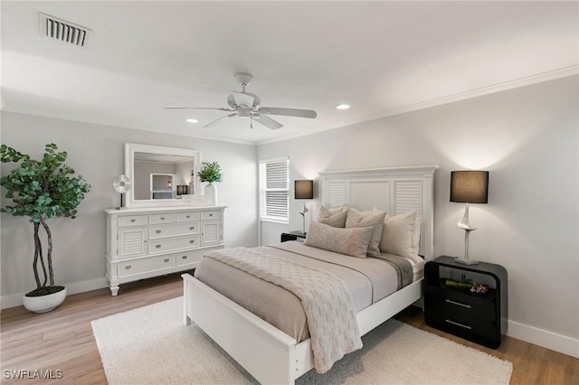 bedroom featuring ceiling fan, light hardwood / wood-style flooring, and crown molding