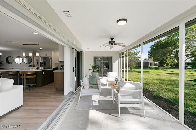 sunroom / solarium featuring ceiling fan