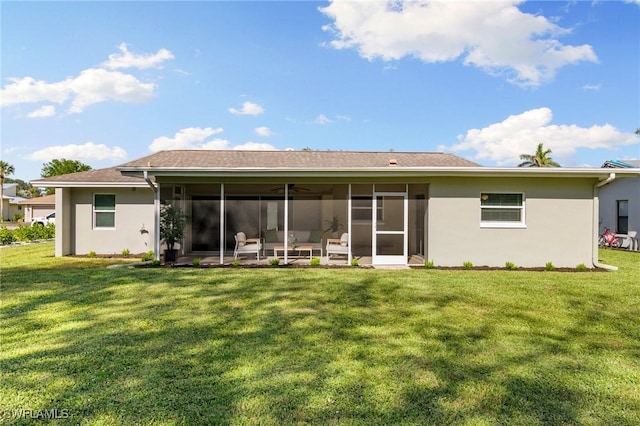 back of house featuring a lawn and a sunroom