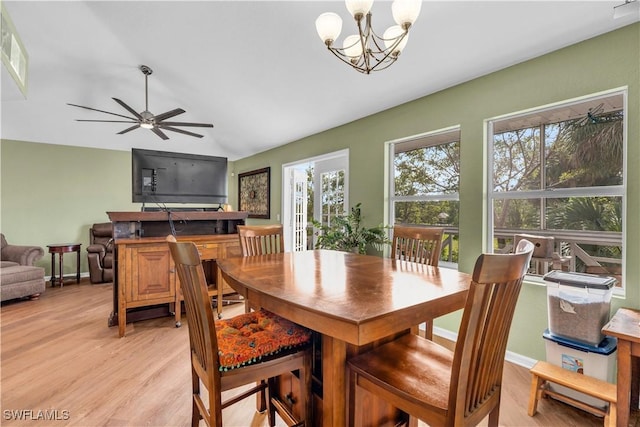 dining room with light hardwood / wood-style flooring, ceiling fan with notable chandelier, and lofted ceiling