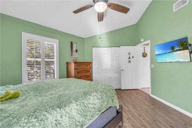 bedroom featuring hardwood / wood-style floors, a closet, ceiling fan, and lofted ceiling