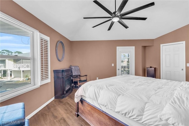 bedroom featuring access to exterior, hardwood / wood-style floors, and ceiling fan