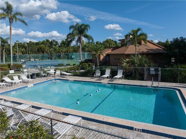 view of pool with tennis court