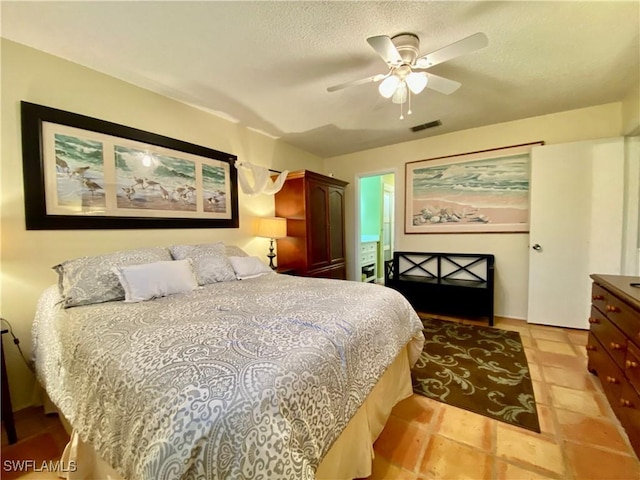 tiled bedroom featuring a textured ceiling and ceiling fan