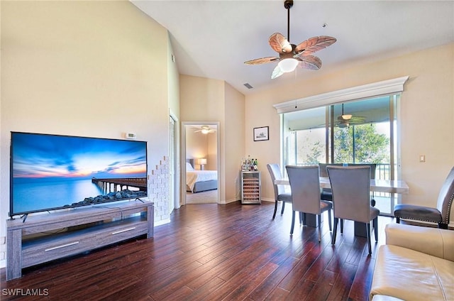 dining space with vaulted ceiling, ceiling fan, and dark wood-type flooring