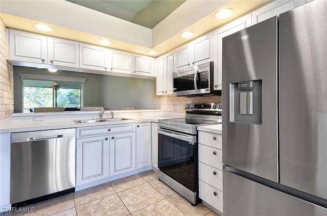 kitchen with white cabinets, light tile patterned floors, stainless steel appliances, and sink