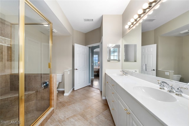 bathroom with tile patterned floors, vanity, toilet, and an enclosed shower