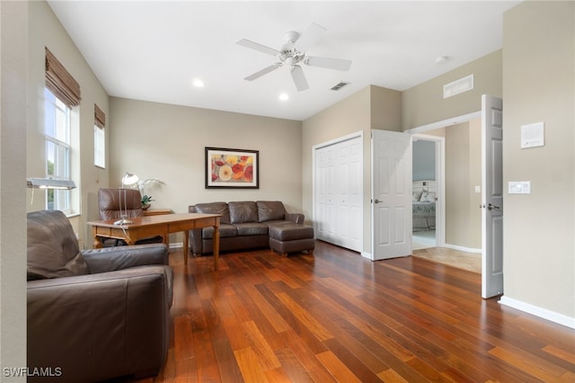 living room with ceiling fan and dark wood-type flooring